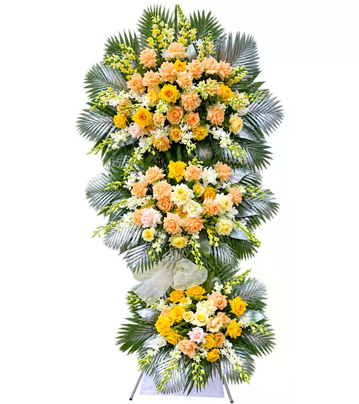 Kệ hoa viếng hồng vàng, lá lớn bạc và vải trắng