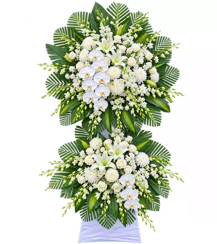 Kệ hoa viếng trắng xanh, lá xanh và vải trắng